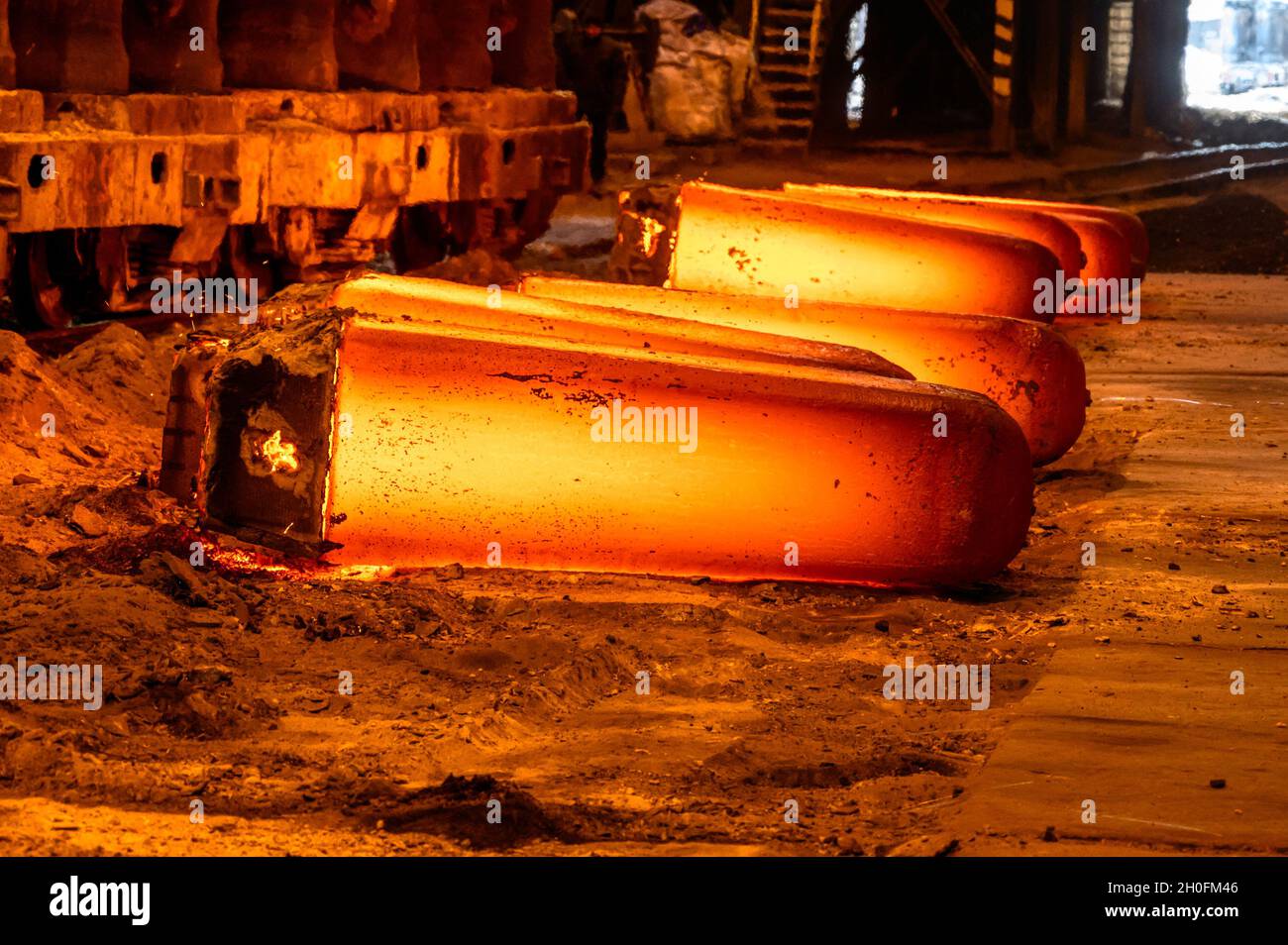 Una forgiatura di metallo rosso-caldo giace sul terreno Foto Stock