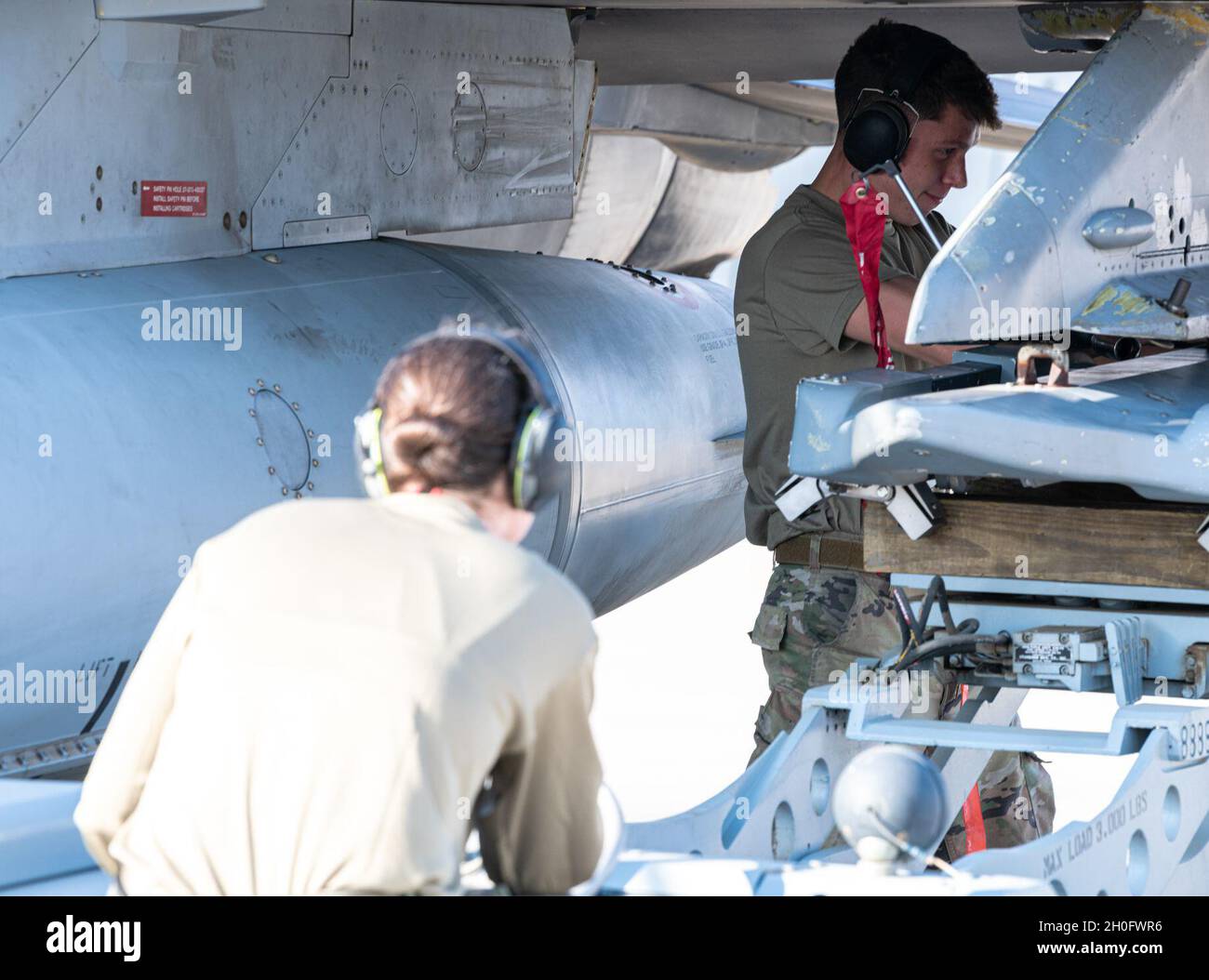 Senior Airman Ramos, 77° membro dell'equipaggio di carico delle armi della generazione dei combattenti di Expeditionary Fighter, guida una munizioni su un F-16 Fighting Falcon prima di un volo durante un evento Agile Combat Employment Capstone il 27 febbraio 2021, presso una base aerea nel Regno dell'Arabia Saudita. Il personale e gli aerei di U.S. Air Forces Central hanno lavorato con partner congiunti e regionali per una serie di attività, tra cui rifornimento di hot-pit e operazioni di scambio di equipaggio, turni di combattimento integrati negli aerei e integrazione di volo partner-nazione durante l'evento della settimana. L'evento segue una serie di eventi ACE in tutto il COM centrale degli Stati Uniti Foto Stock