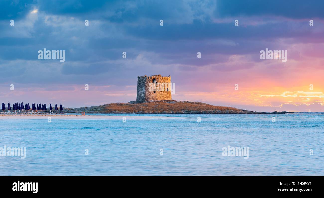 Splendida alba sulla Torre Aragonese e sulla spiaggia la Pelosa bagnata da una tranquilla acqua turchese. Spiaggia la Pelosa, Stintino, Sardegna nord-occidentale. Foto Stock