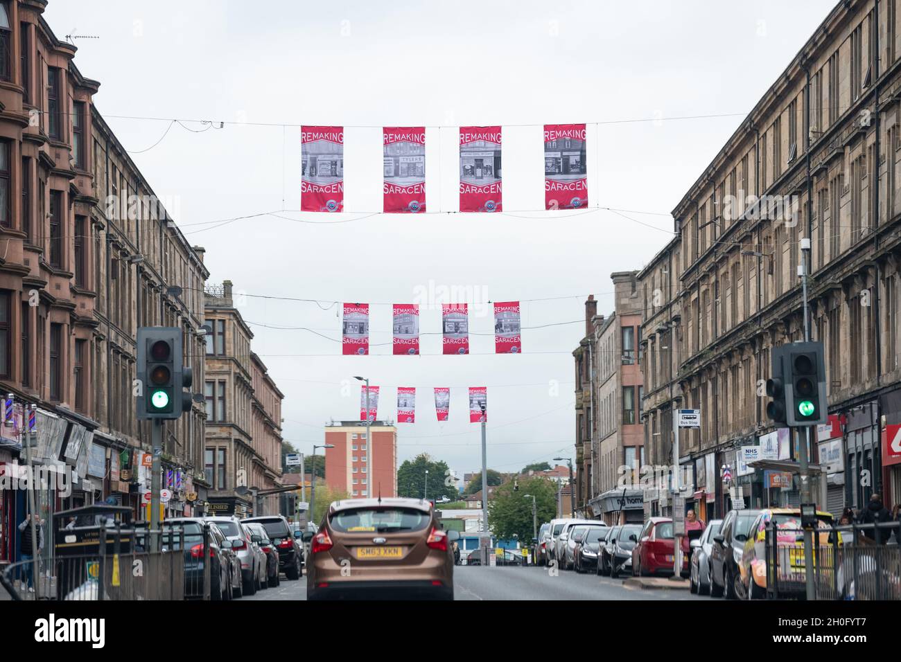 Saracen Street, Possilpark, Glasgow, Scozia, Regno Unito con la rifacimento dei banner con logo Saracen creati dal designer Maeve Redmond per Possilpark BID Foto Stock