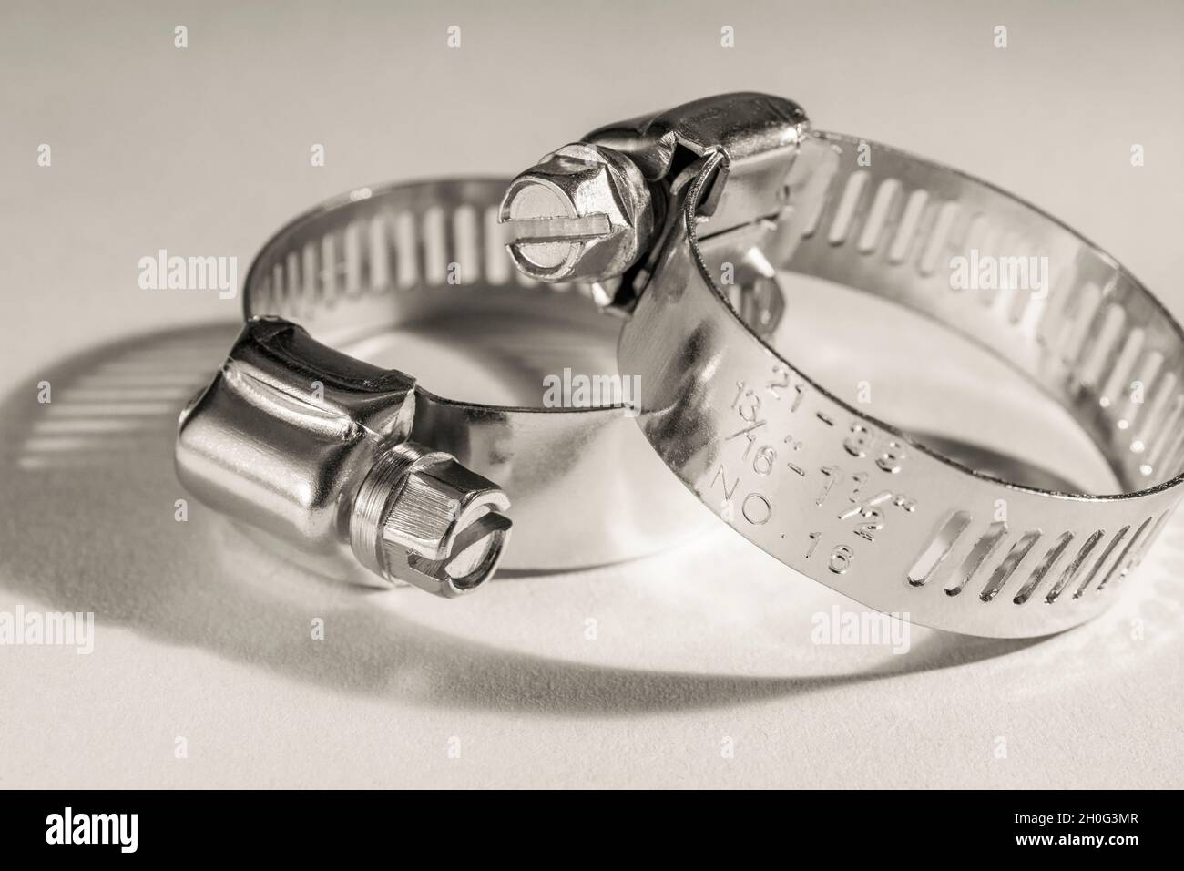 Primo piano astratto delle clip per tubo con attacco a vite senza fine Jubilee clip (queste non sono il vero marchio Jubilee). Per elementi di fissaggio fai da te, usi di metallo. Foto Stock