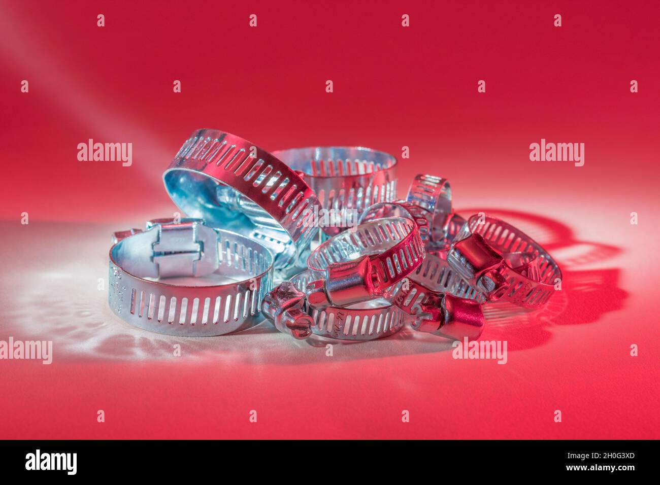 Primo piano astratto delle clip per tubo con attacco a vite senza fine Jubilee clip (queste non sono il vero marchio Jubilee). Per elementi di fissaggio fai da te, usi di metallo. Foto Stock