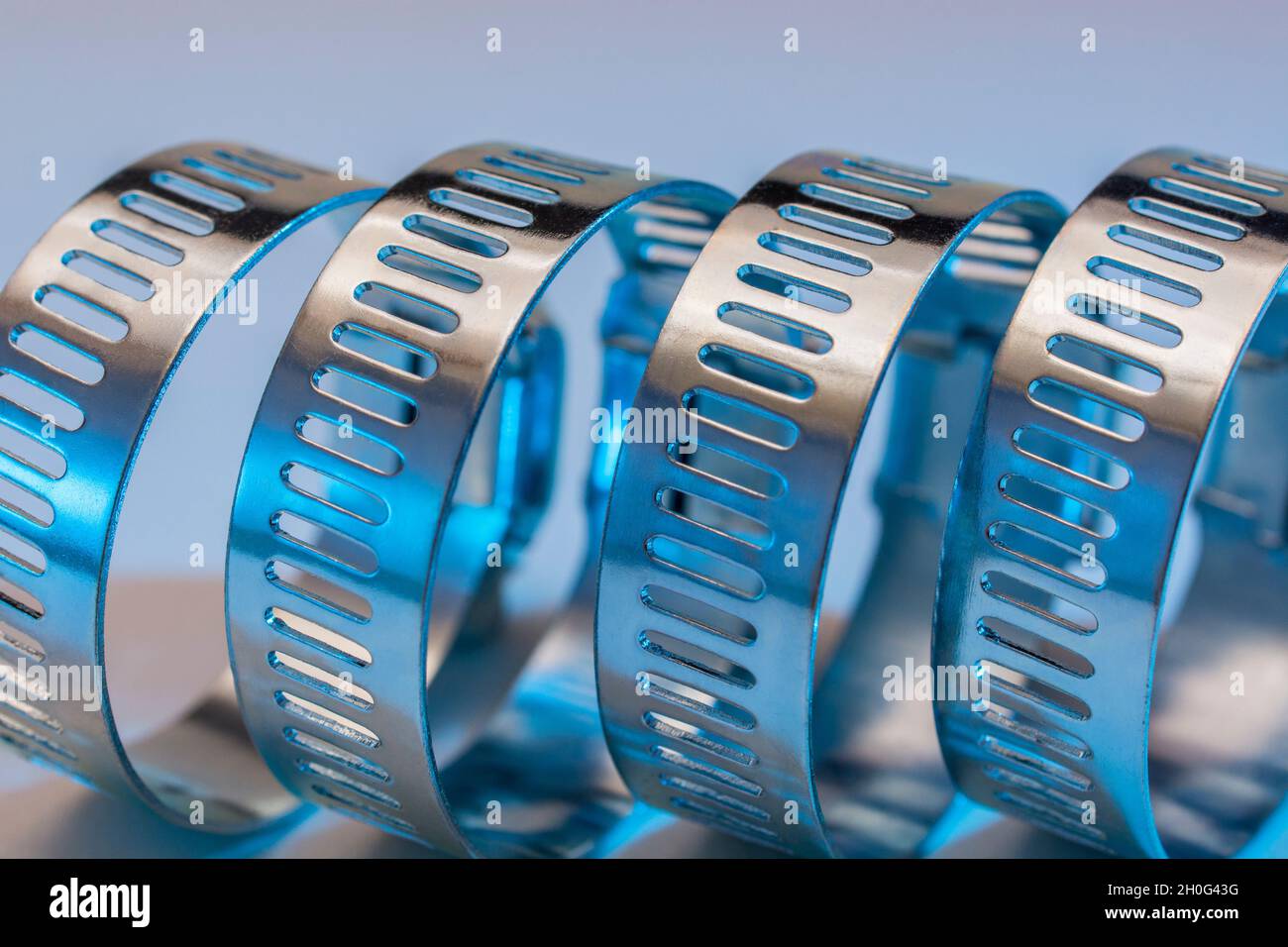 Primo piano astratto delle clip per tubo con attacco a vite senza fine Jubilee clip (queste non sono il vero marchio Jubilee). Per elementi di fissaggio fai da te, usi di metallo. Foto Stock