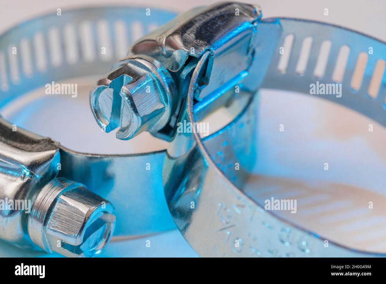 Scatto di chiusura del tipo di clip Jubilee di clip per tubo flessibile con attacco a vite senza fine (questi non sono il vero marchio Jubilee). Per il fissaggio fai-da-te, usi di metallo, in un idioma fisso. Foto Stock