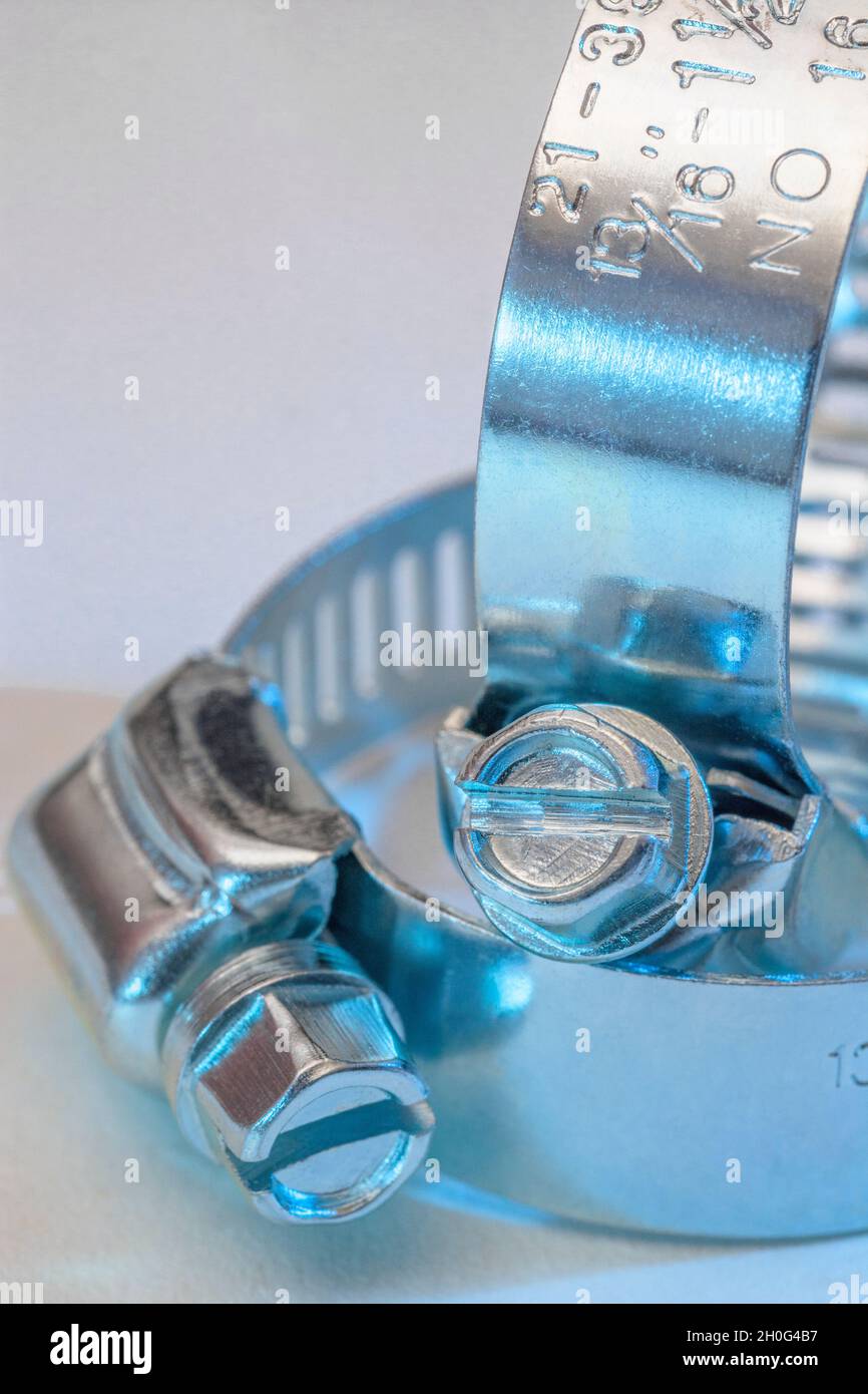 Scatto di chiusura del tipo di clip Jubilee di clip per tubo flessibile con attacco a vite senza fine (questi non sono il vero marchio Jubilee). Per il fissaggio fai-da-te, usi di metallo, in un idioma fisso. Foto Stock