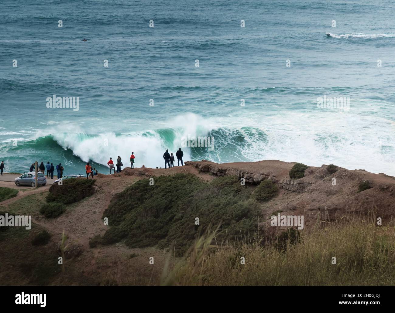 La gente guarda le grandi onde a Nazare - Nazare, Portogallo Foto Stock