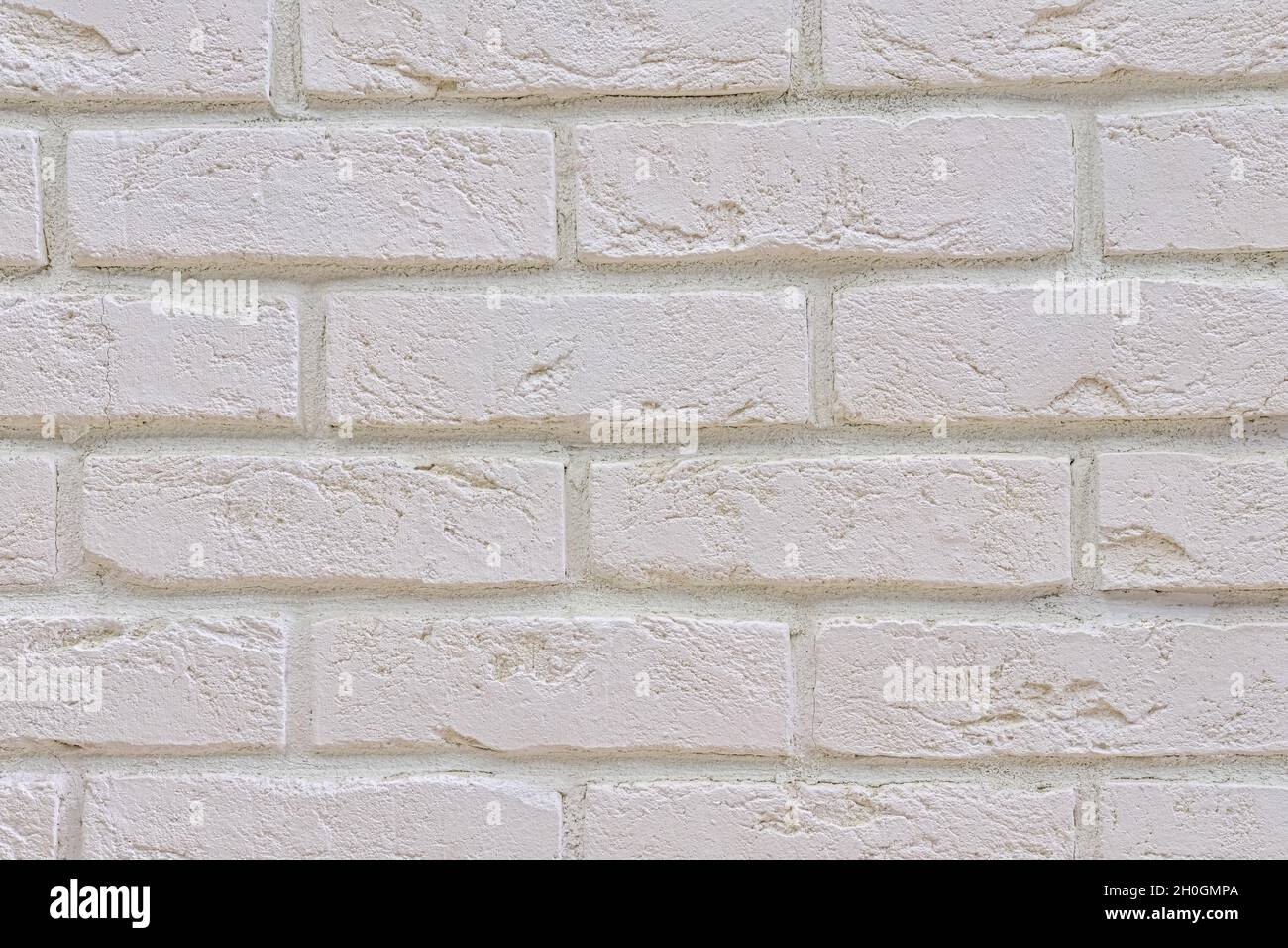 Superficie dipinta di bianco e fresco di facciata in mattoni di un vecchio edificio rinnovato. Sfondo bianco muro di mattoni. Foto Stock
