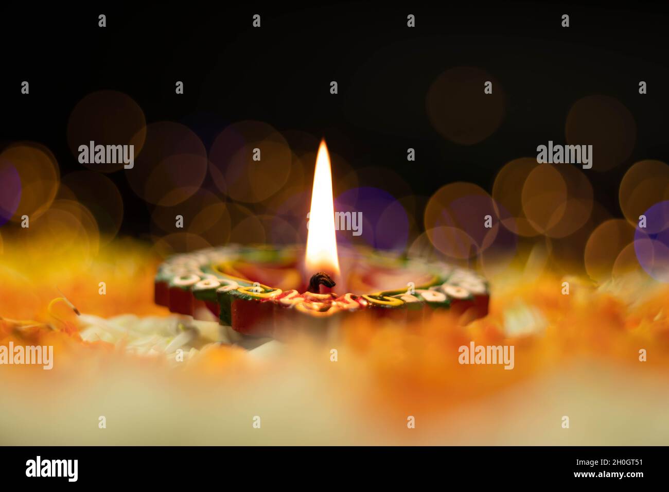 Fuoco selettivo - fiamme dritte affilate illuminanti da Clay Diya Deep dia con effetto Bokeh. Tema del Festival indiano per Diwali Pooja, Navratri, Duss Foto Stock