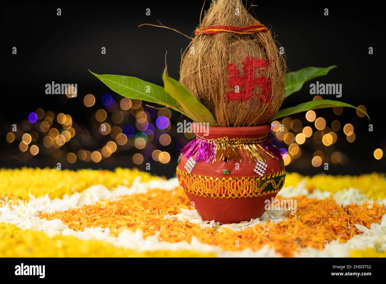 Terracotta Clay Pot Kalash decorato con cocco, foglia di mango posto su Rangoli fiore di Marigold. Usato in Navratri Pooja, Dussehra Puja, Karva Chaut Foto Stock