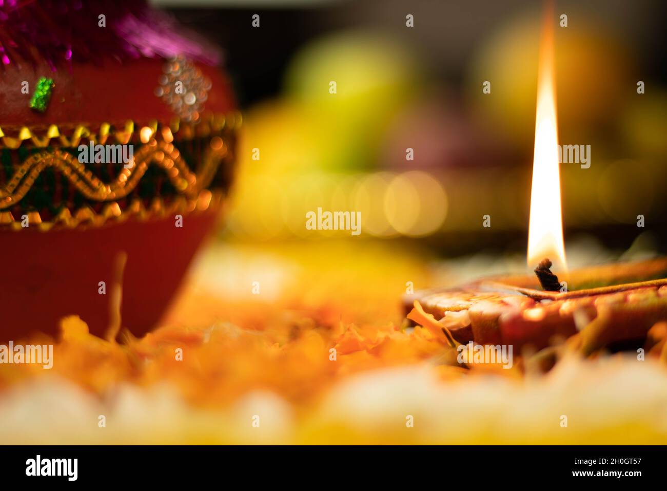 Fuoco selettivo - fiamme dritte affilate illuminanti da Clay Diya Deep dia con effetto Bokeh. Tema del Festival indiano per Diwali Pooja, Navratri, Duss Foto Stock