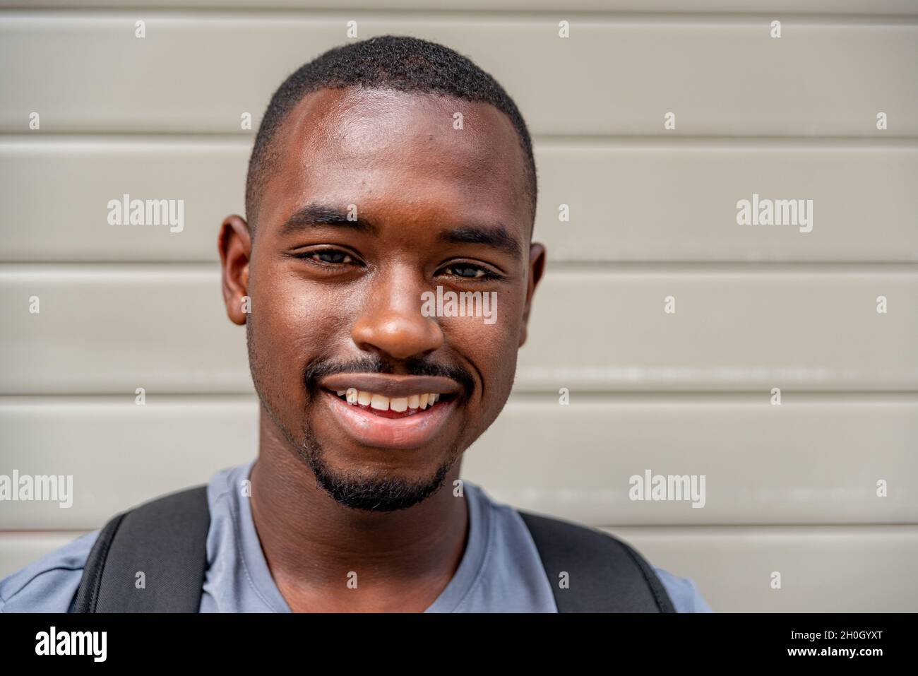 Ritratto di afro giovane sorridente all'aperto Foto Stock