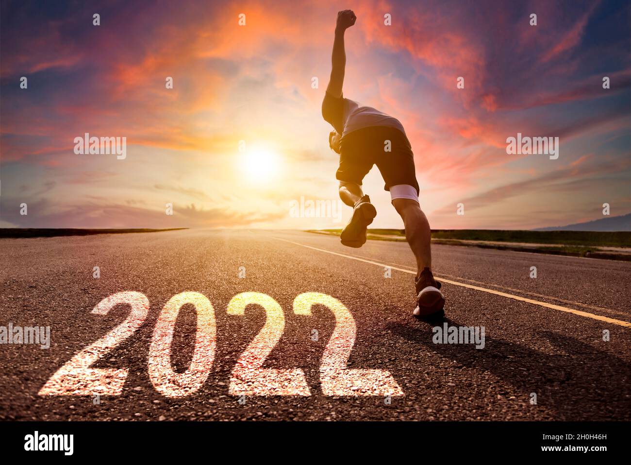 Uomo che corre e si spinning su strada con 2022 nuovo anno concetto Foto Stock