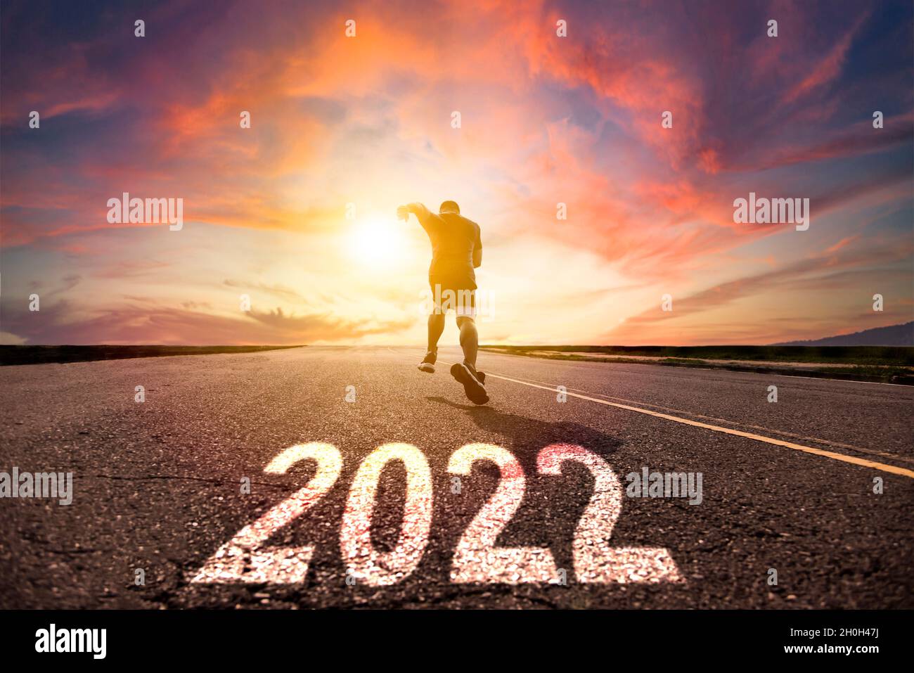 Uomo che corre e si spinning su strada con 2022 nuovo anno concetto Foto Stock