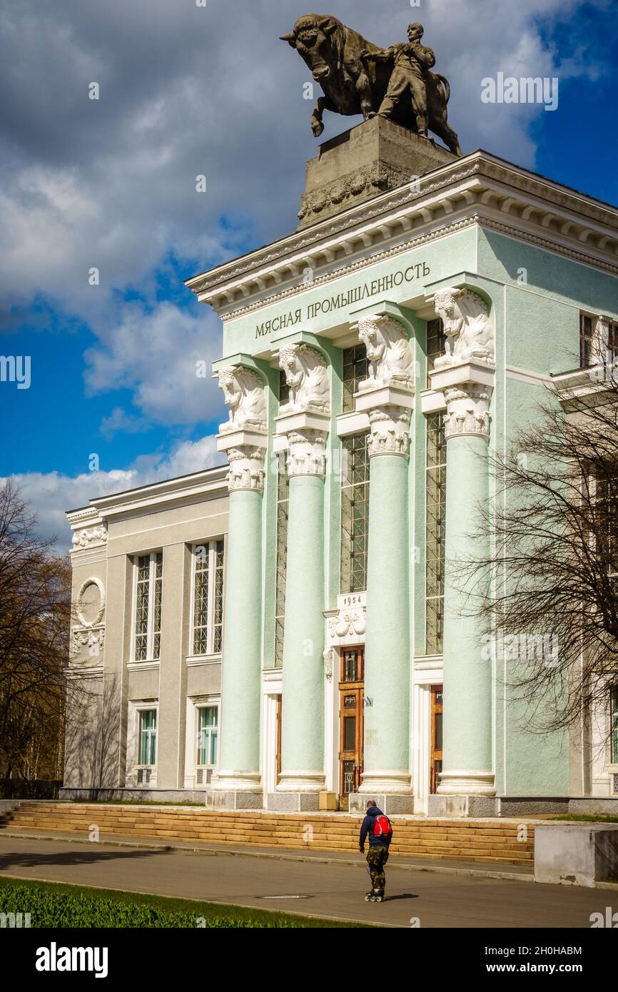 Mosca, Russia, 23 aprile 2016: Un rullo-Blader passa oltre il Padiglione dell'industria della carne alla Mostra dei risultati dell'economia nazionale a Mosca, Foto Stock