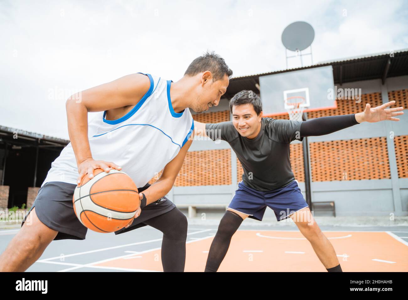 il giocatore di basket dribble la palla faccia a faccia con il giocatore  avversario Foto stock - Alamy