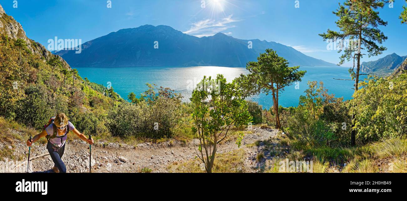 Escursionista sulla sponda occidentale del Lago di Garda con la catena montuosa Monte Baldo, Limone sul Garda, Brescia, Lago di Garda Ovest, Lombardia, Italia Foto Stock