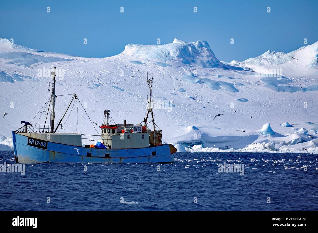 Nave da pesca di fronte agli iceberg, Disko Bay, Winter, Ilulissat, Groenlandia, Danimarca Foto Stock