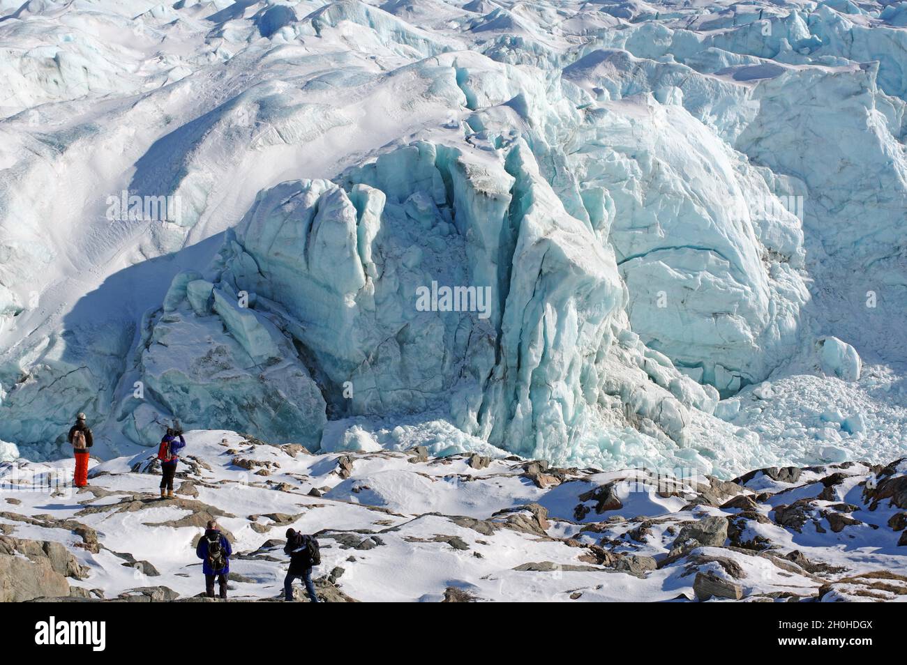 Persone di fronte a crepacci e ghiaccio di fronte a un ghiacciaio, Russell Glacier, Kangerlussuaq, Groenlandia, Danimarca Foto Stock