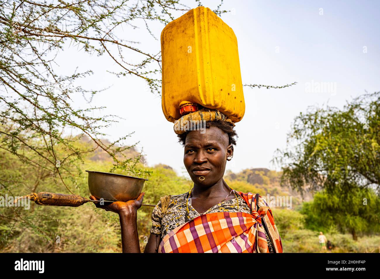 Donna con un canister in acqua sulla testa, tribù laarim, colline di Boya, Equatoria orientale, Sudan meridionale Foto Stock