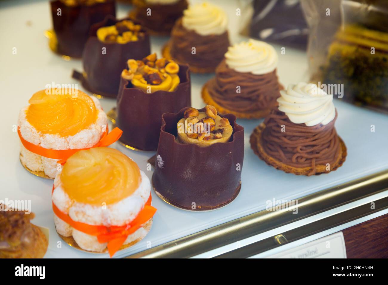 Dolci vegani dietro un bicchiere di vetrina caffè Foto Stock