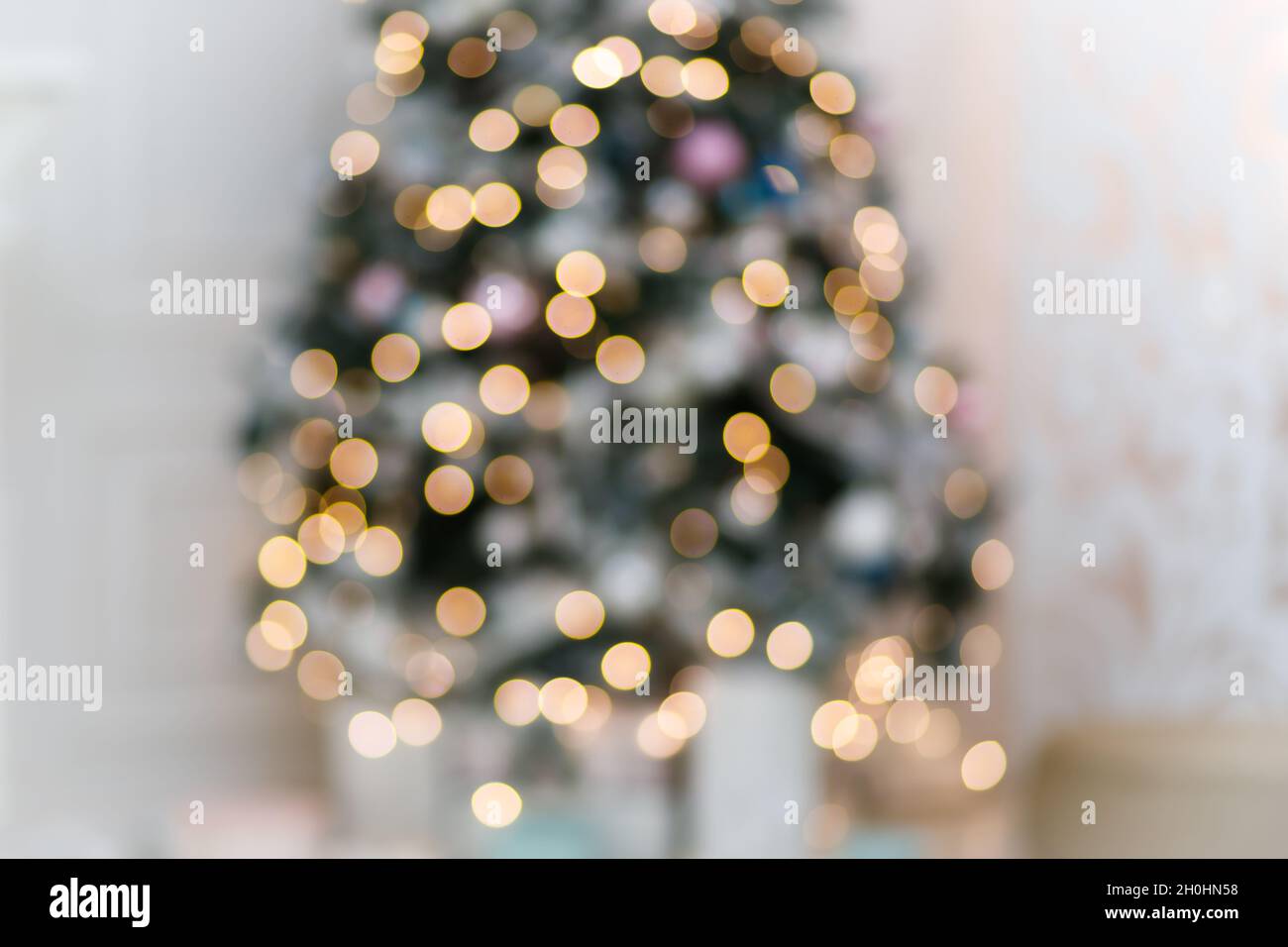 Luci di ghirlanda festive sull'albero di natale in sfondo bianco sfocato  interno Foto stock - Alamy