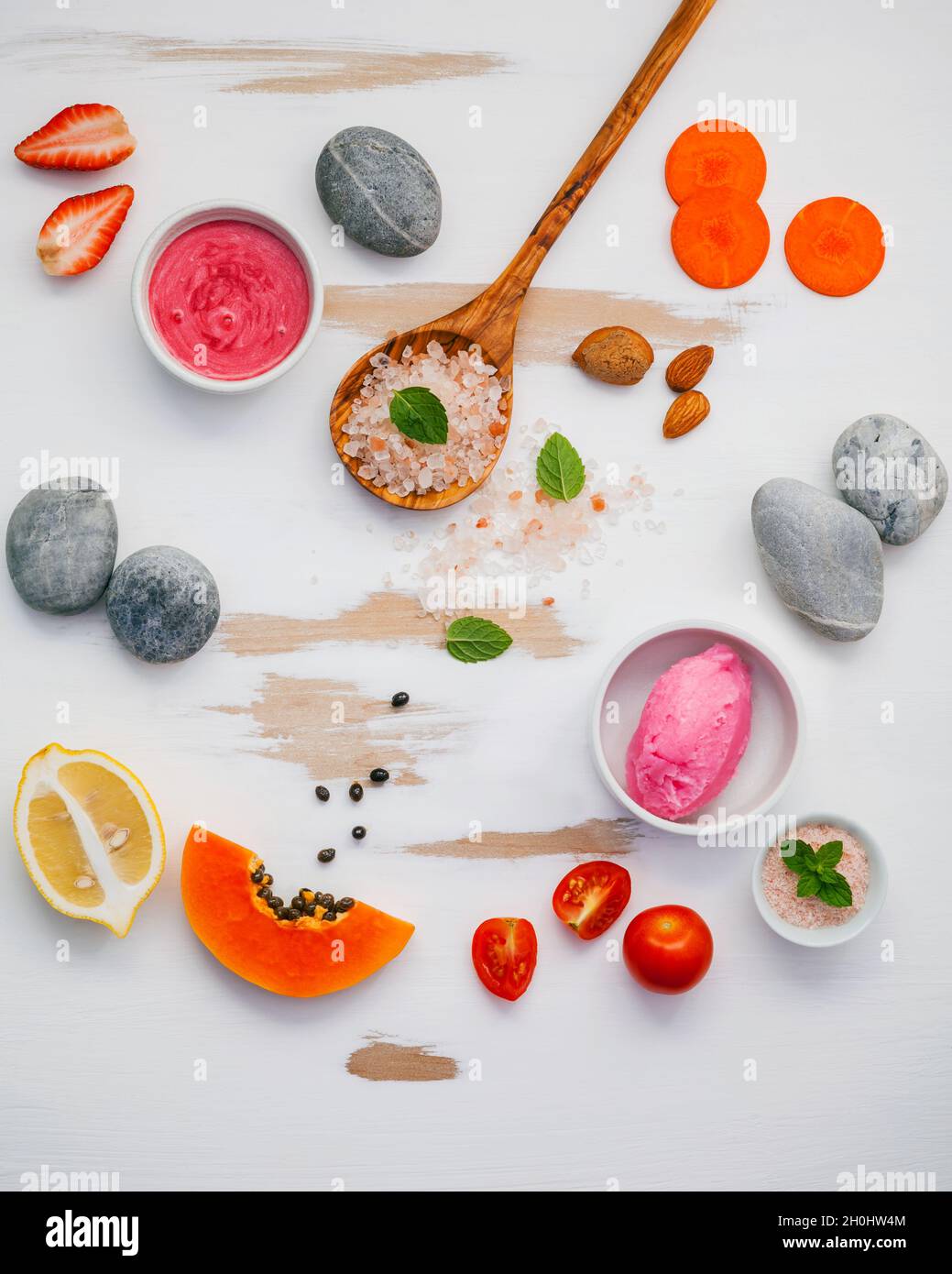 In casa di cura di pelle e scrub corpo rosso con ingredienti naturali fragola , Pomodoro ,Sale Himalayano,papaia, la carota e la pietra sul bianco backgrou in legno Foto Stock
