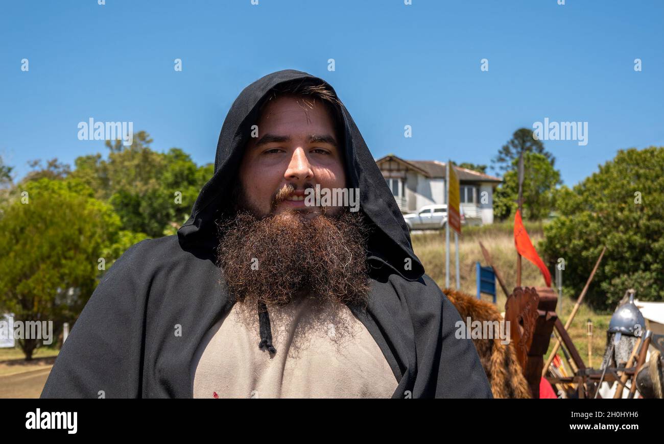 Eungella, Queensland, Australia - Ottobre 2021: Un uomo barbuto in costume nero con cappuccio in un villaggio vichingo medievale rievocazione nel paese Foto Stock