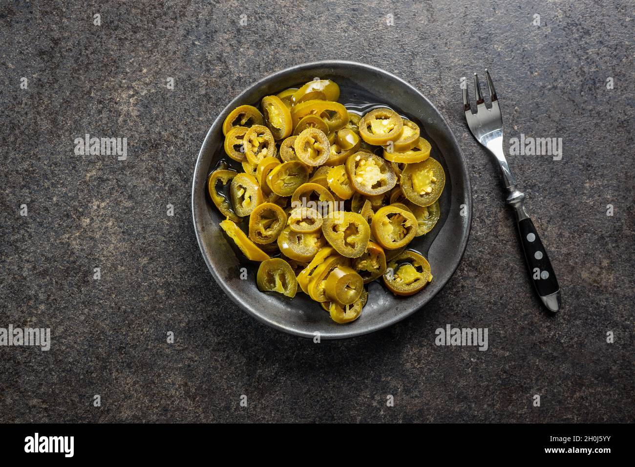 Jalapeno affettato in salamoia. Peperoni verdi jalapeno sul piatto. Vista dall'alto. Foto Stock
