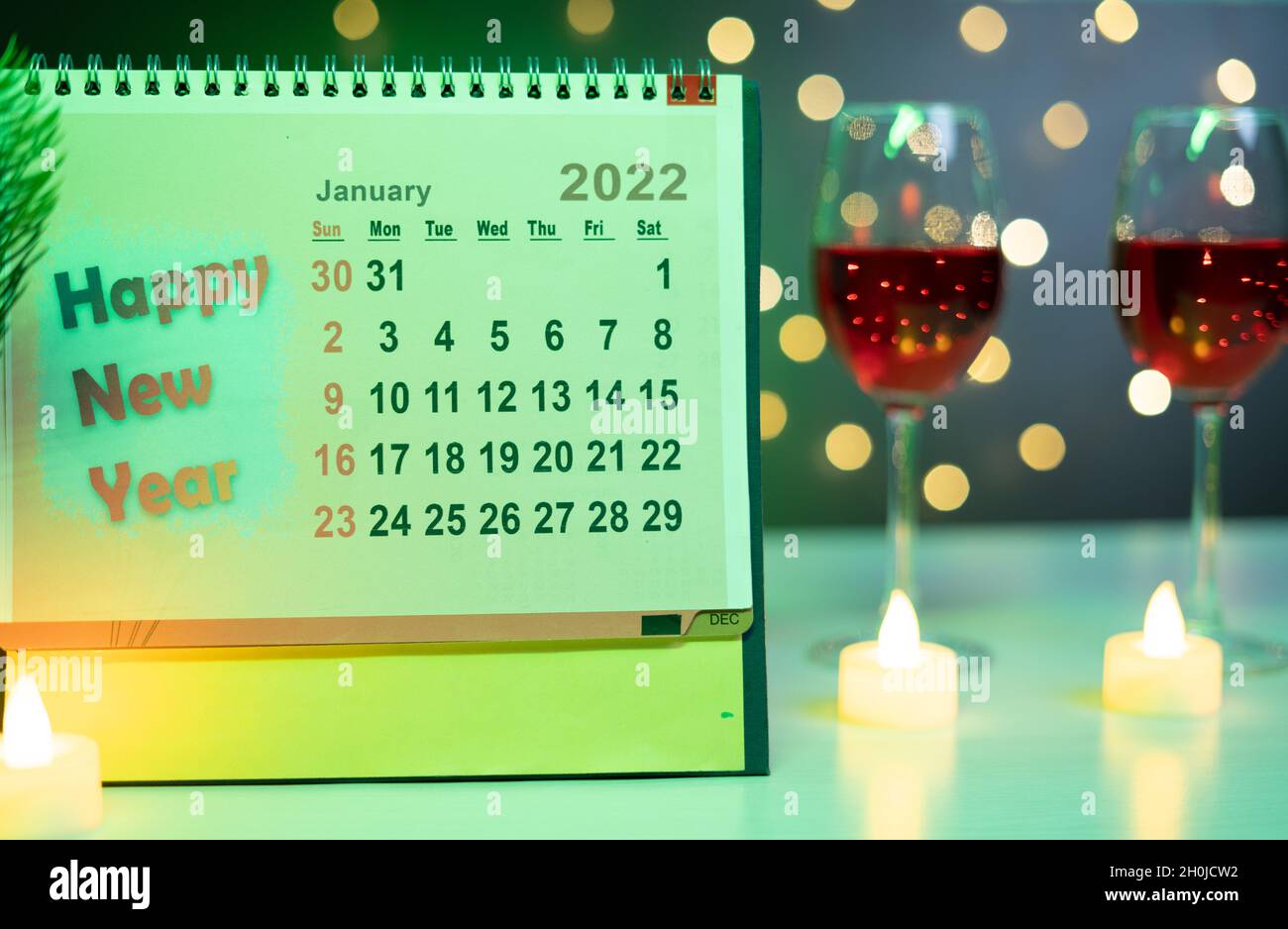 Focus sul calendario del nuovo anno 2022, concetto di festa di nuovo anno da champagne bevande dietro il calendario su sfondo decorato festa illuminazione Foto Stock
