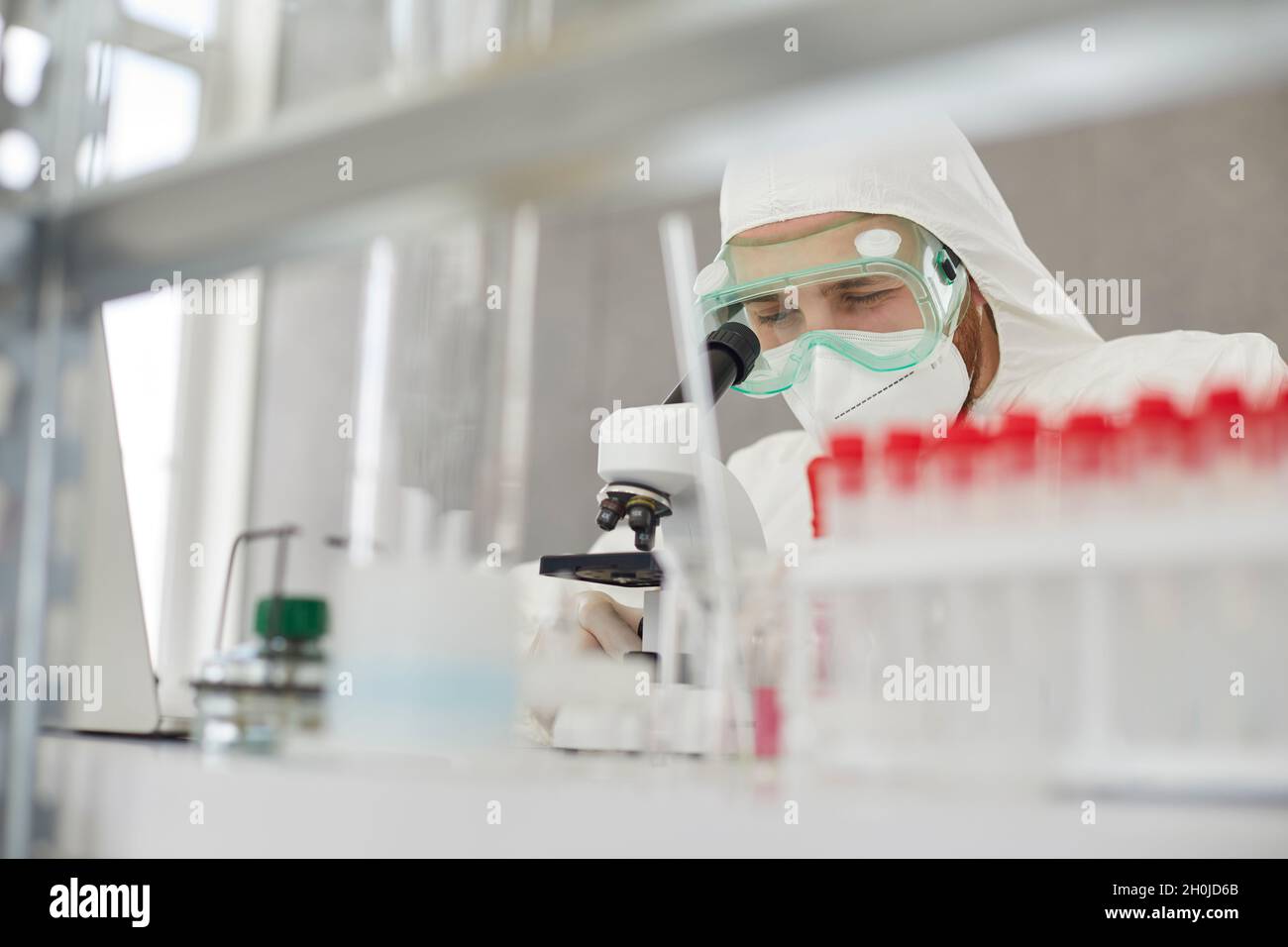 Medico scientifico in PPE studio nuovo virus e lavoro sul nuovo vaccino in laboratorio Foto Stock