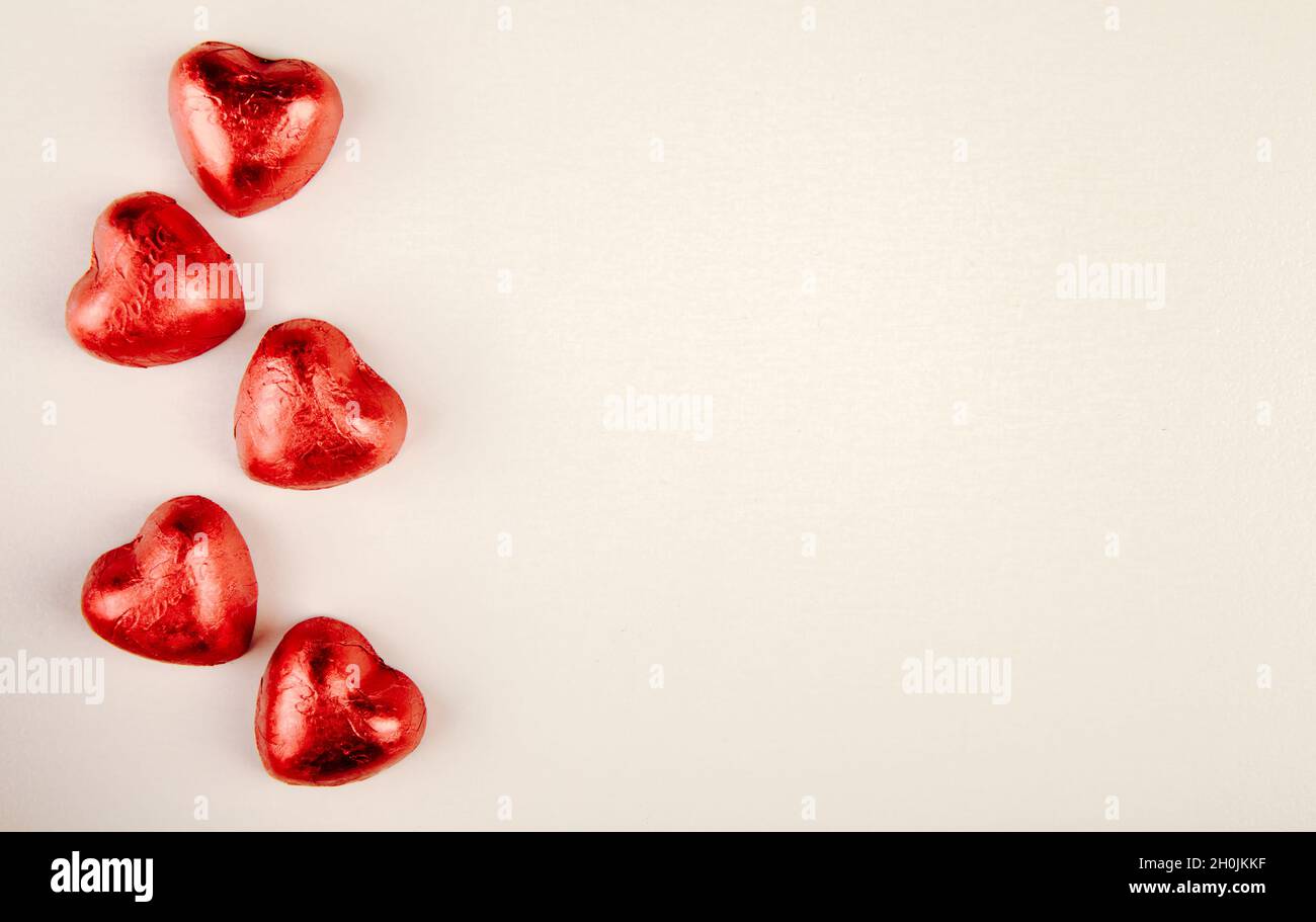 vista dall'alto di caramelle rosse a forma di cuore isolate su sfondo bianco con spazio per la copia Foto Stock