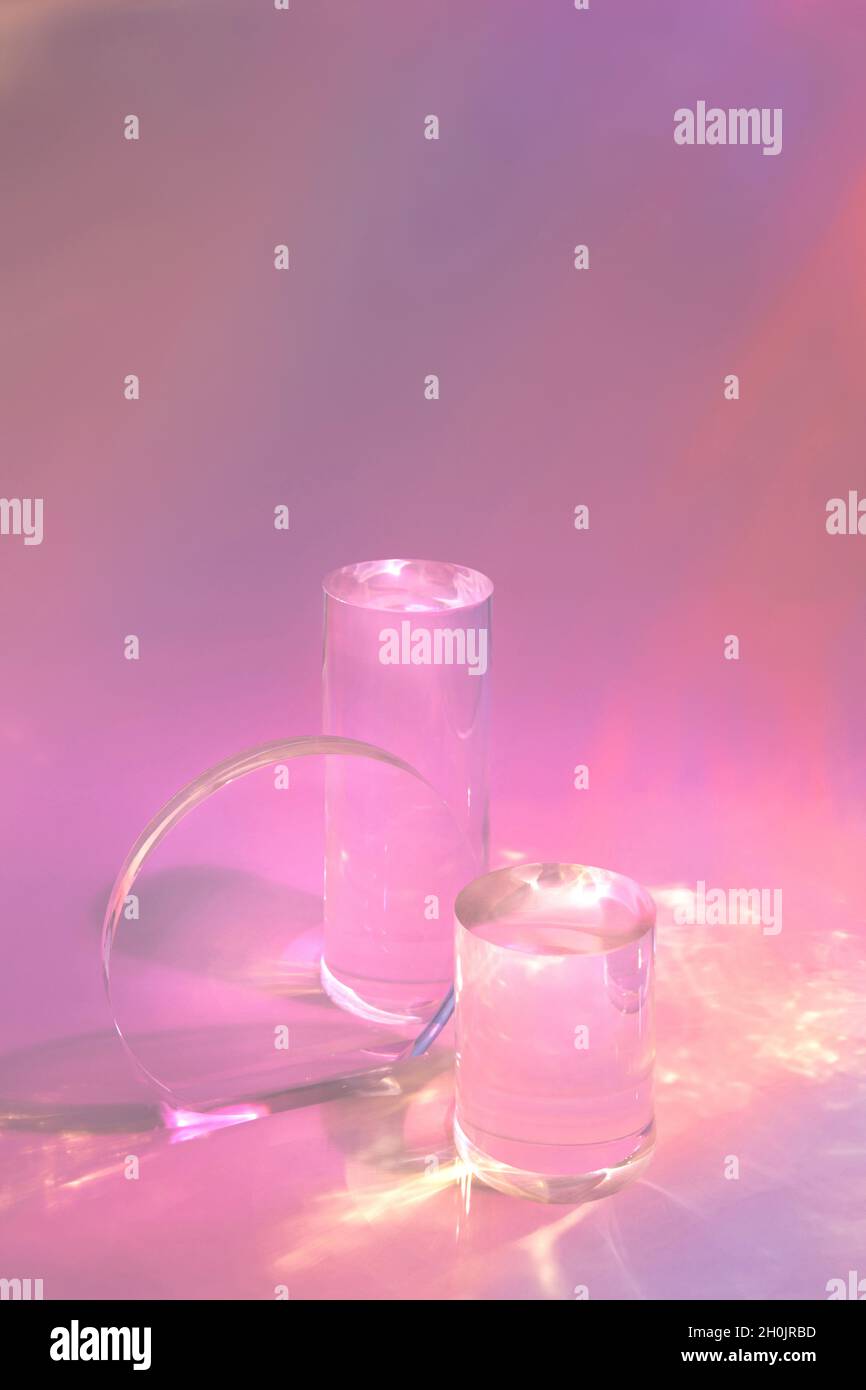 due podi in vetro trasparente su sfondo rosa pastello Foto Stock