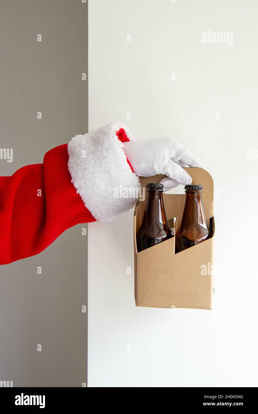 Babbo Natale che mostra un pacchetto di 4 birre artigianali con le mani Foto Stock Babbo Natale che mostra un pacchetto di 4 birre artigianali con le mani Foto Stock