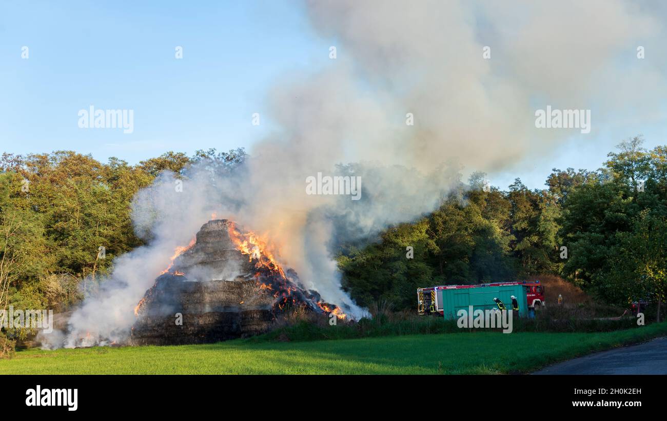 I vigili del fuoco cercano di estinguere balle di fieno bruciate Foto Stock