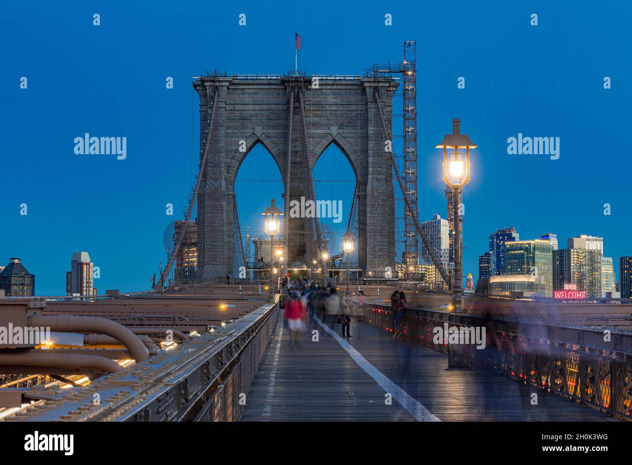 Pedoni che camminano sul Ponte di Brooklyn di notte, New York City USA Foto Stock