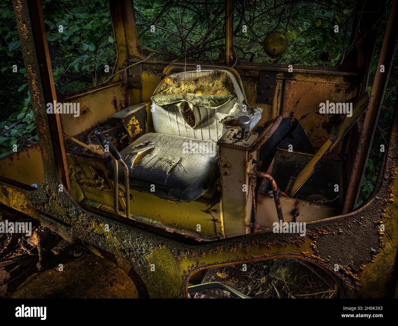 Sedile strappato all'interno del bulldozer arrugginito abbandonato Foto Stock