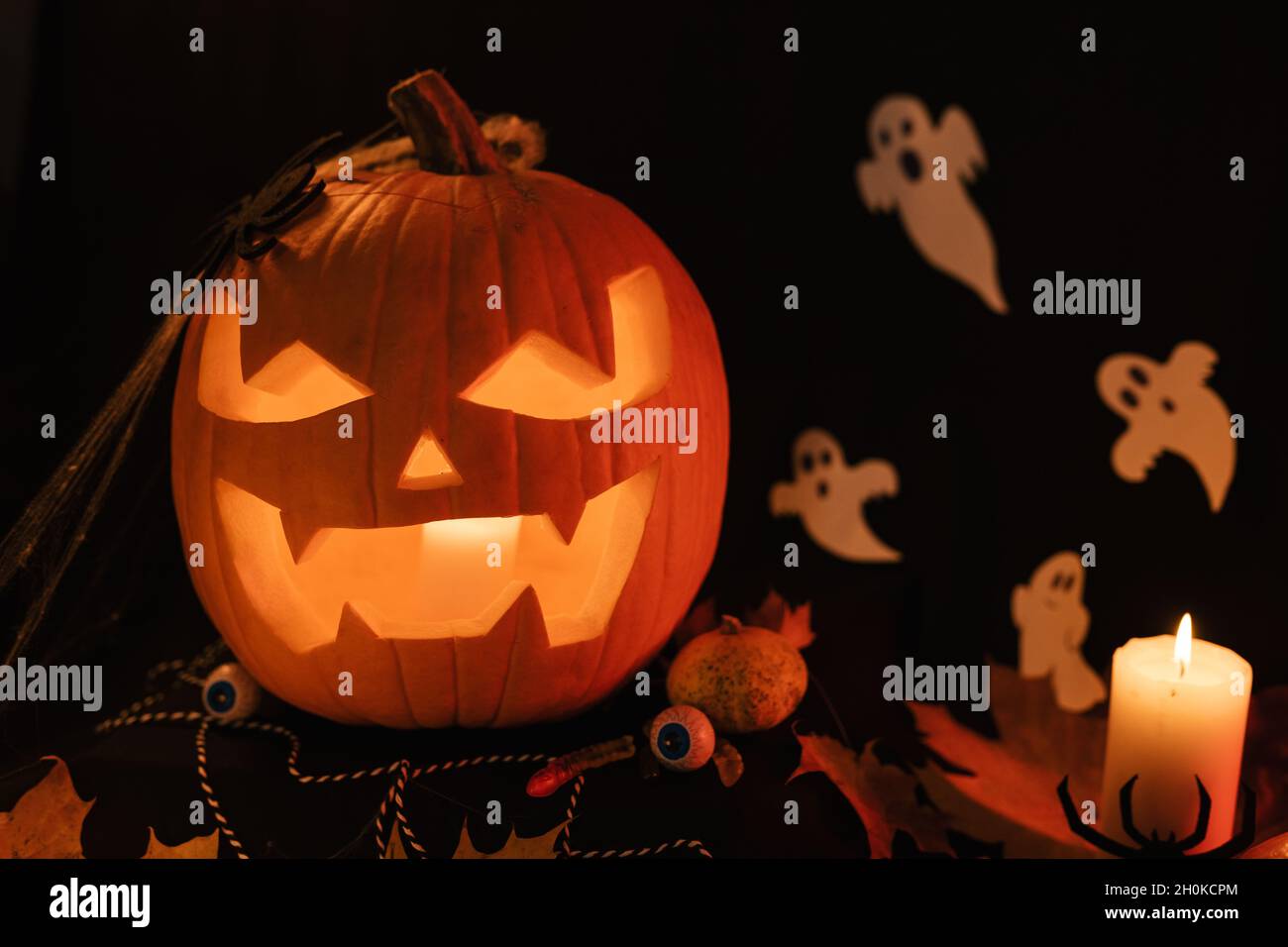 Decorazione di Halloween sul tavolo. Zucca di Halloween. Prelibatezze tradizionali. Primo piano in Pumpkin con grande paura. Zucca incandescente Foto Stock