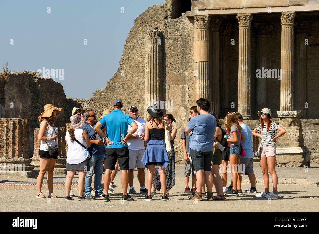 Pompei, Italia - Agosto 2019: Gruppo di persone che ascolta una guida turistica che spiega la storia di Pompei Foto Stock