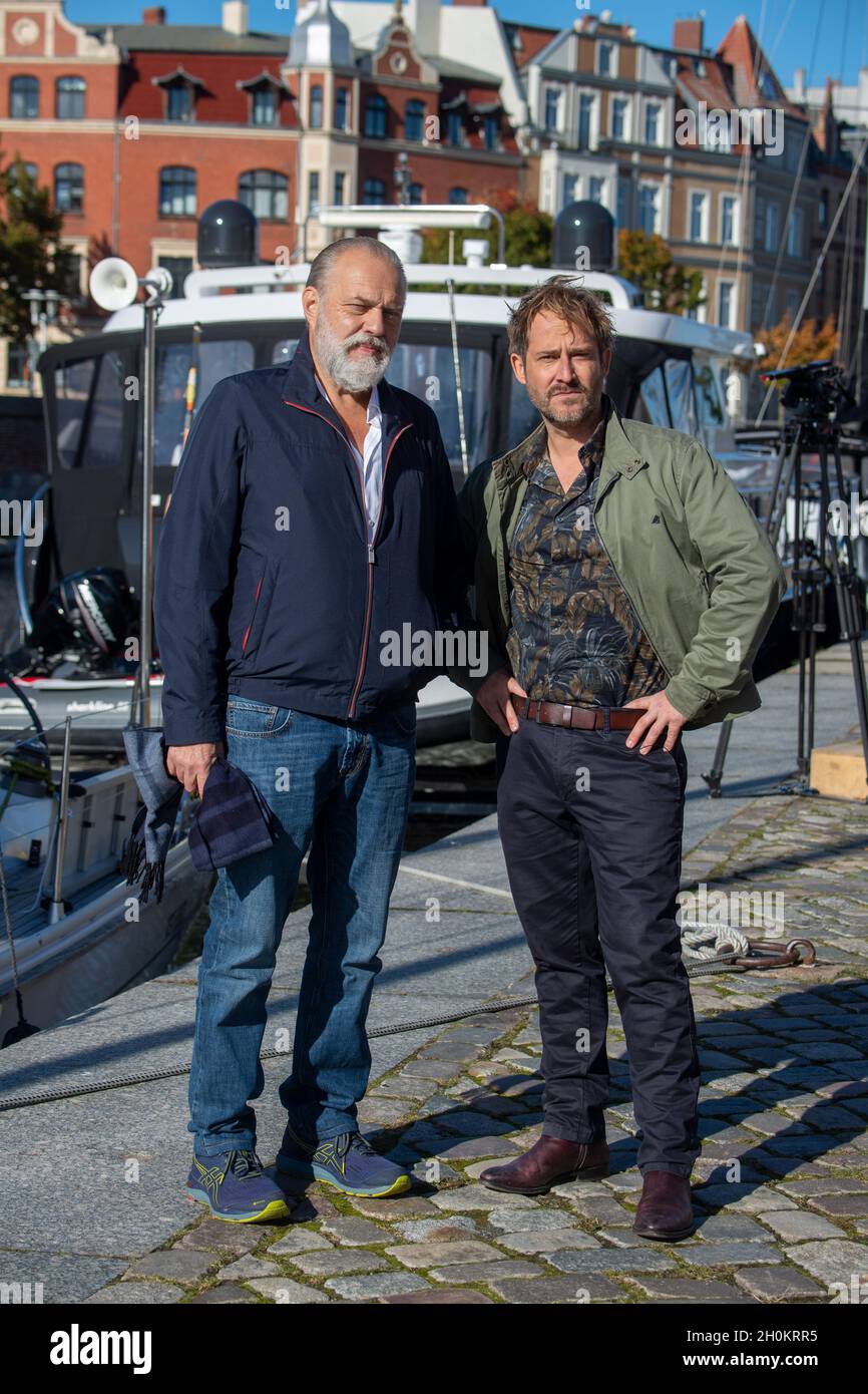 Stralsund, Germania. 13 ottobre 2021. L'attore Jan-Gregor Kremp (l) come Ispettore Richard Voss e Niels Bruno Schmidt come Ispettore Heinritz si levano in piedi al margine delle riprese in scena per lo speciale di 90 minuti della serie criminale ZDF 'Der Alte'. Con il titolo di lavoro 'Der Alte - Tod am Cliff' (il Vecchio uomo - la morte sulla scogliera), le riprese proseguiranno sull'isola di Rügen e a Stralsund fino probabilmente all'ottobre 22. Non è stata ancora impostata una data di trasmissione. Credit: Stefan Sauer/dpa/Alamy Live News Foto Stock
