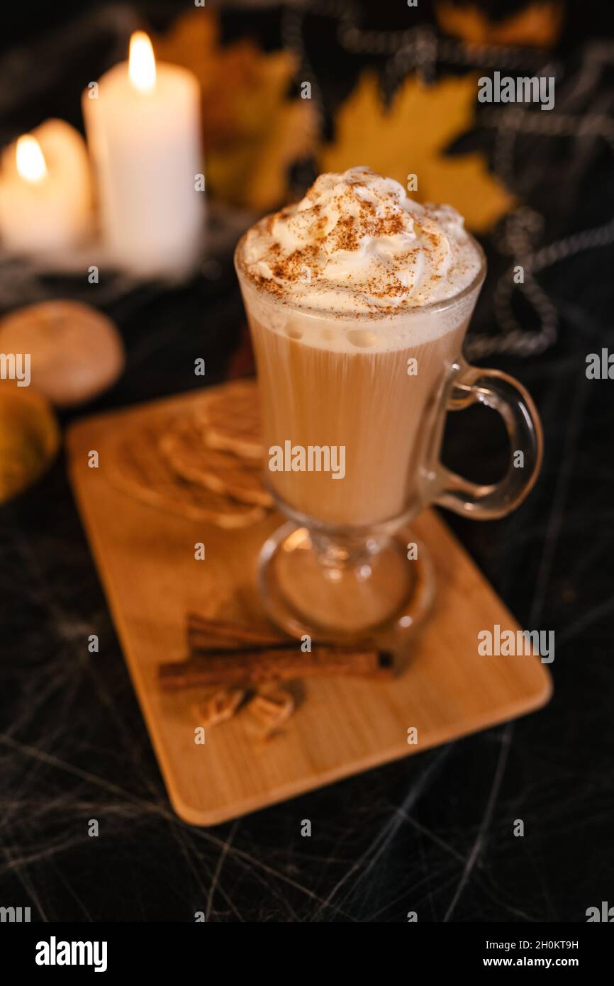 Latte di Halloween. Caffè latte piccante in decorazioni di Halloween. Zucca, latte, Halloween, contenuti commerciali. Tazza di caffè sul tavolo di Halloween Foto Stock
