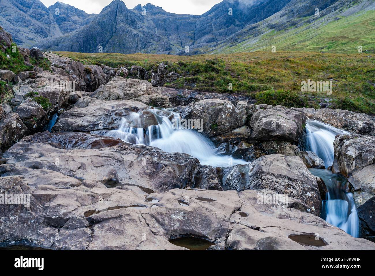 Piscine fairy e una cascata sul fiume fragile ai piedi del Cuillins Nero, Isola di Skye, Scozia. Esposizione prolungata Foto Stock