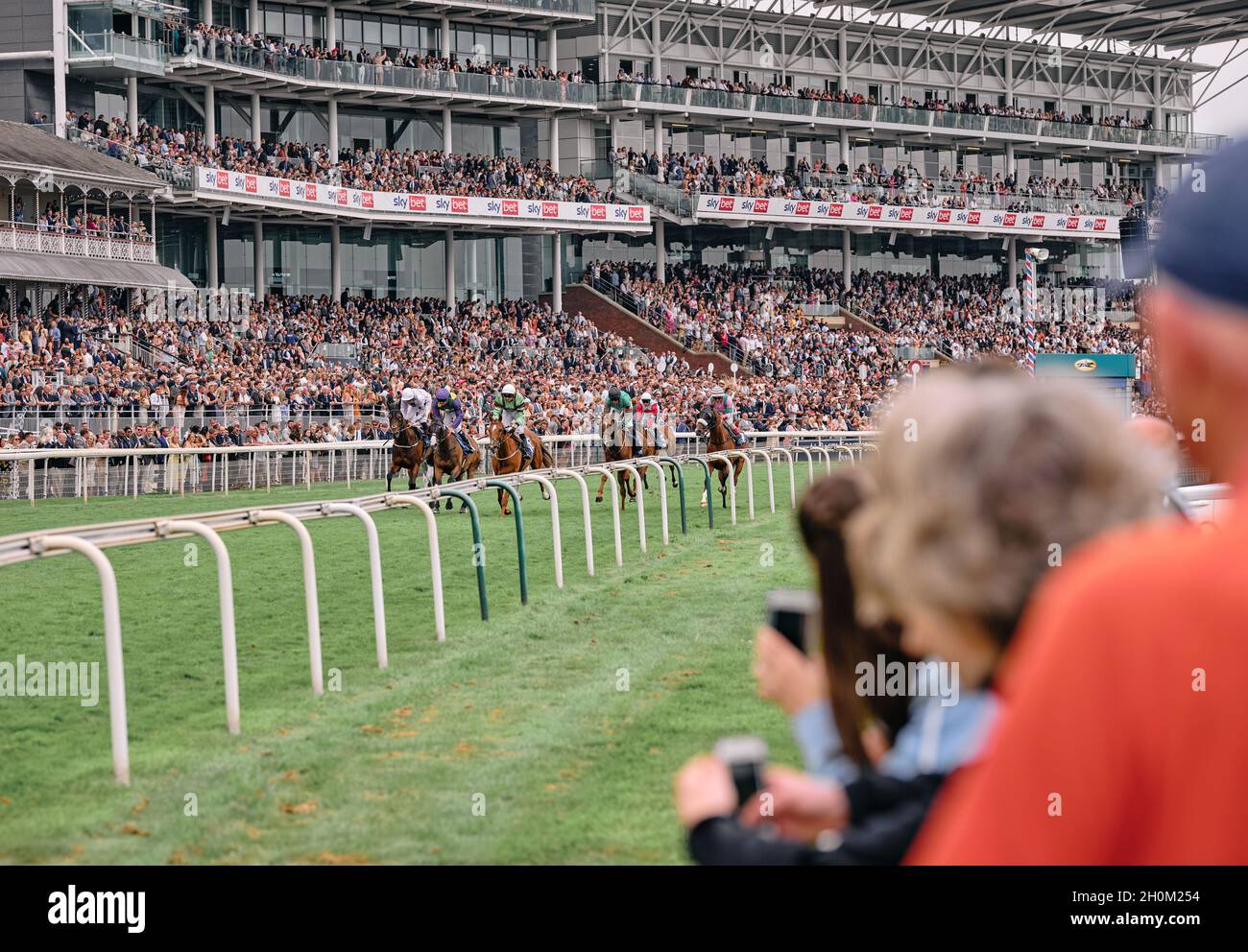 Un giorno alle corse - Racegoers acclamare sopra ad una corsa di cavallo del giorno in un evento di fine settimana estivo all'ippodromo di York York, Yorkshire, Inghilterra UK 2021 Foto Stock