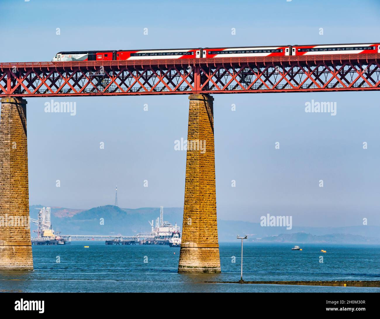 Treno LNER attraversando Ponte di Forth Rail sulla giornata di sole, con Hound Point, Firth of Forth, Scotland, Regno Unito Foto Stock