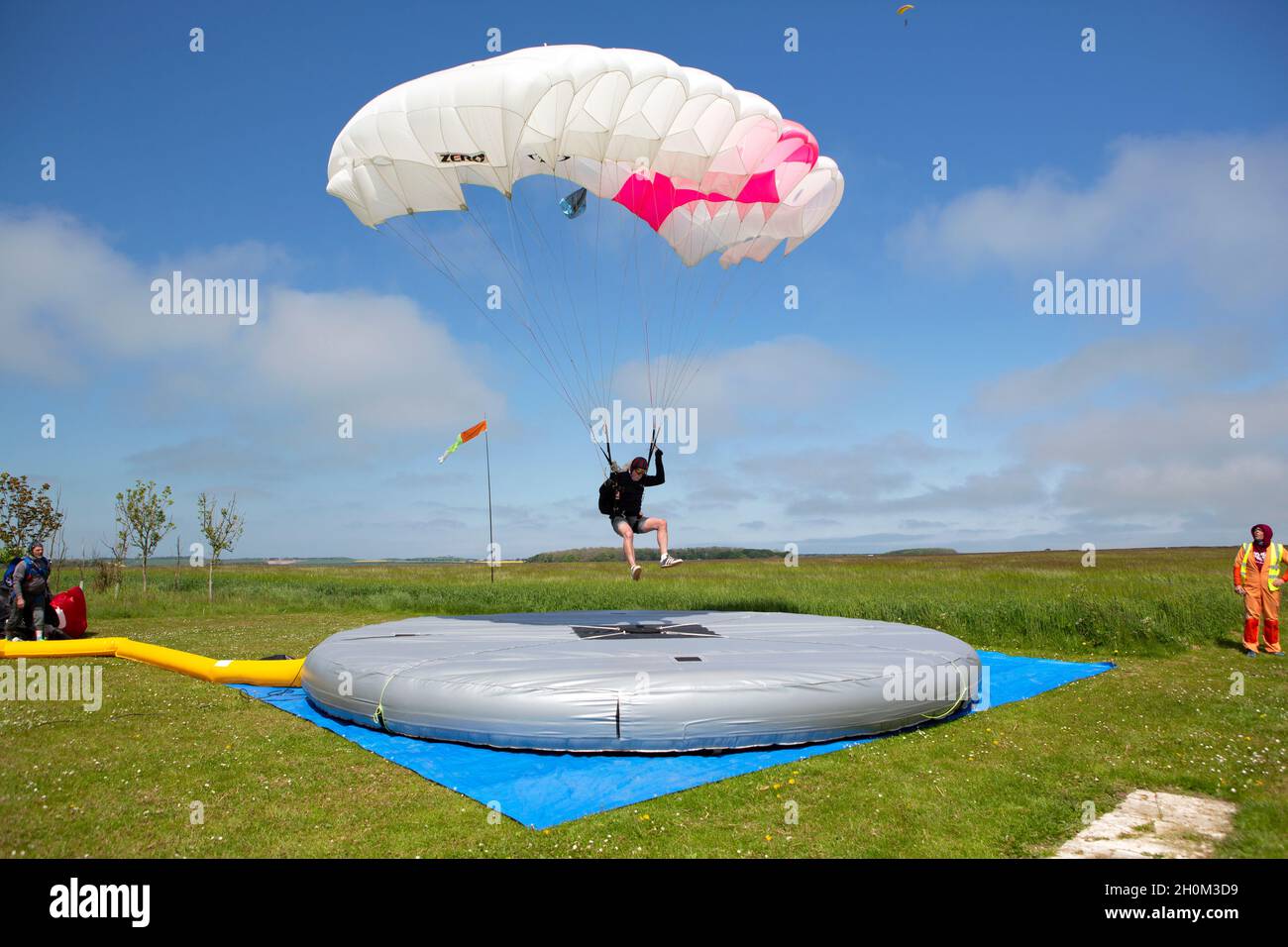 Uno Skydiver arriva a atterrare su una speciale zona di atterraggio che ha un cuscinetto di pressione al centro che misura quanto vicino si può arrivare al centro. Cielo Foto Stock