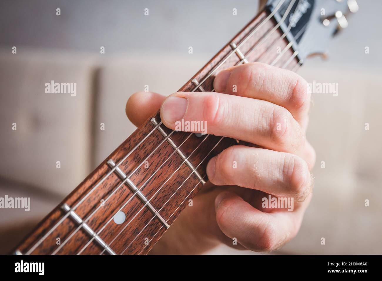 G Chord - la mano caucasica maschile close-up prende un accordo su una chitarra a 6 corde Foto Stock