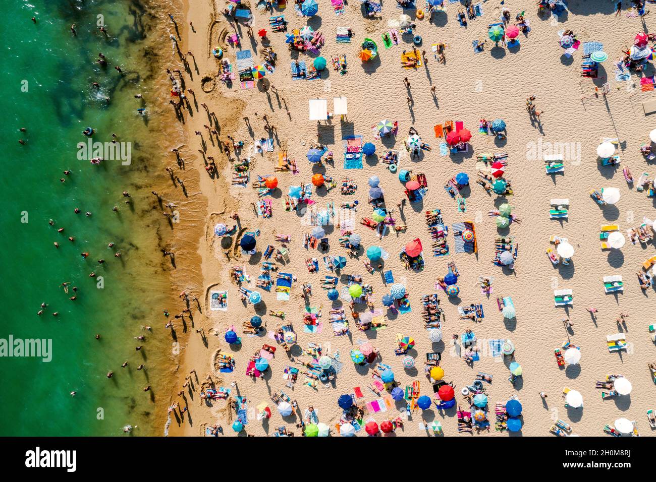 Drone shot di molte persone che godono la spiaggia e l'oceano - modello di vacanza. Rocha Beach a Portimao, Portogallo Foto Stock