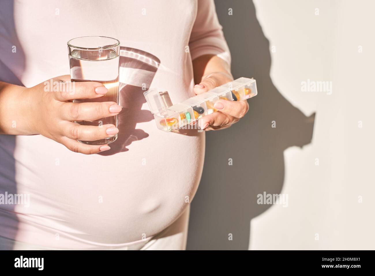 Donna incinta mangiare pillole di gravidanza. Integratori influenzali. Assunzione di farmaci allergici. Foto Stock