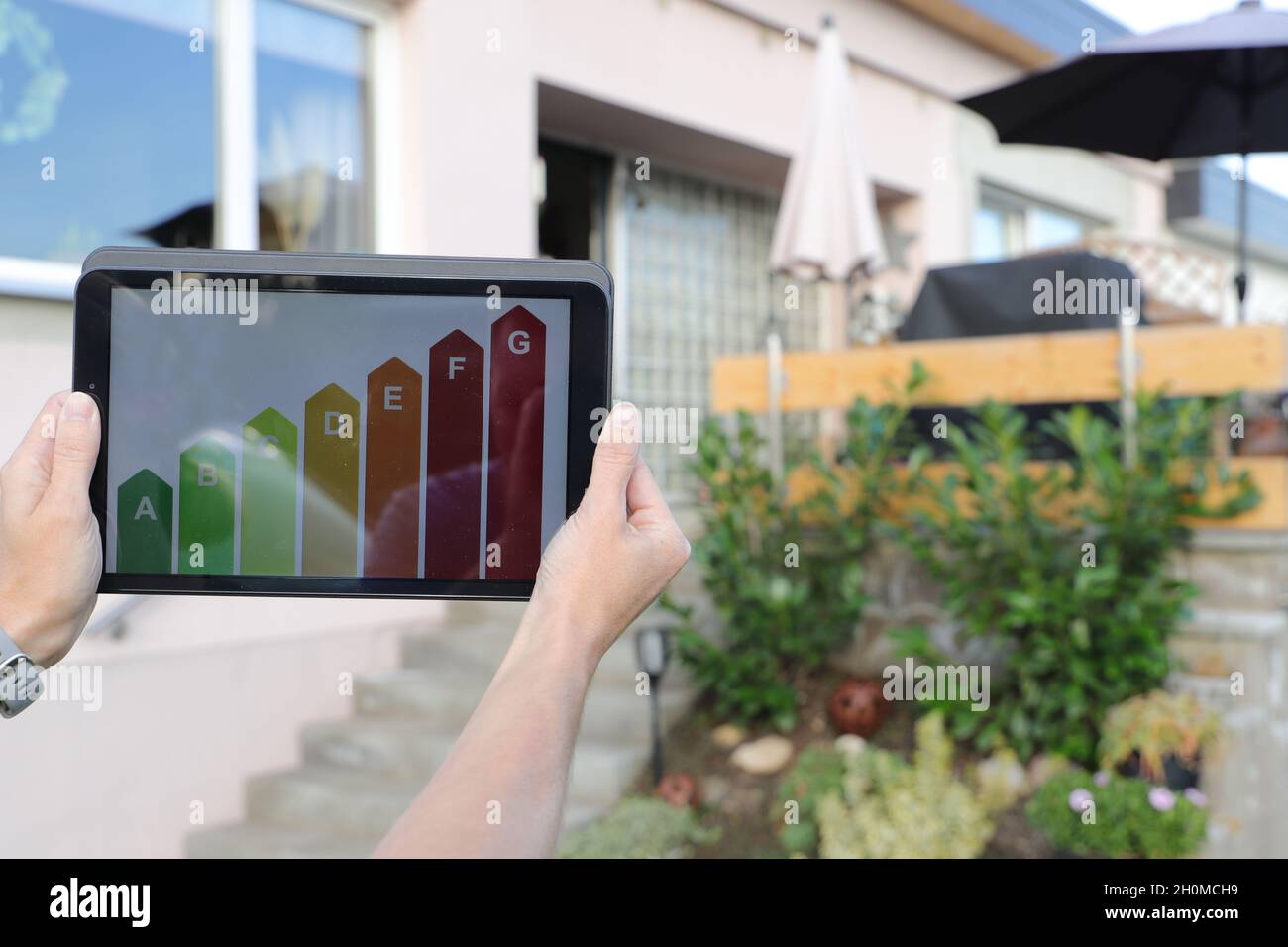 Etichetta energetica su un tablet con una casa in background Foto Stock