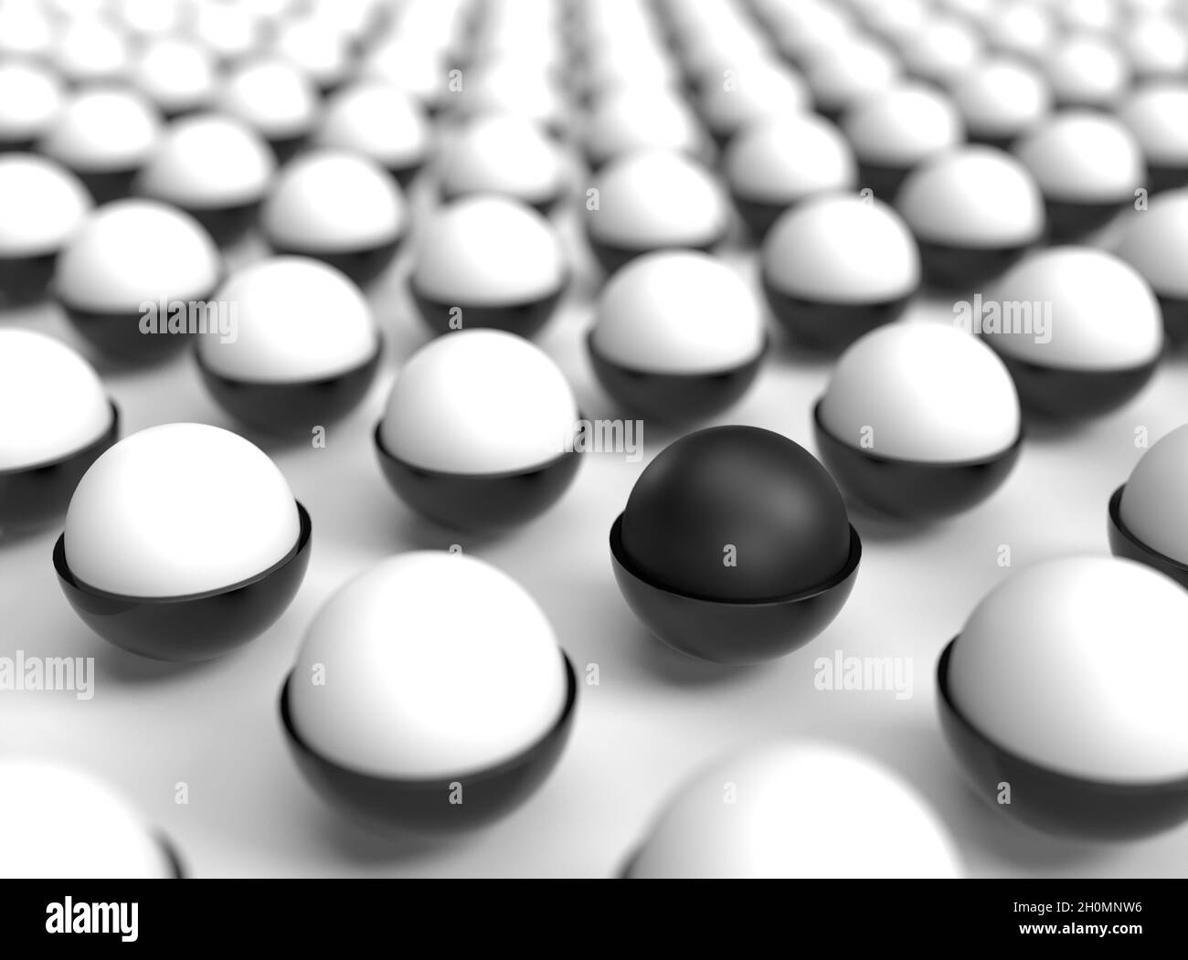 Una singola palla nera in un campo di palline bianche Foto Stock