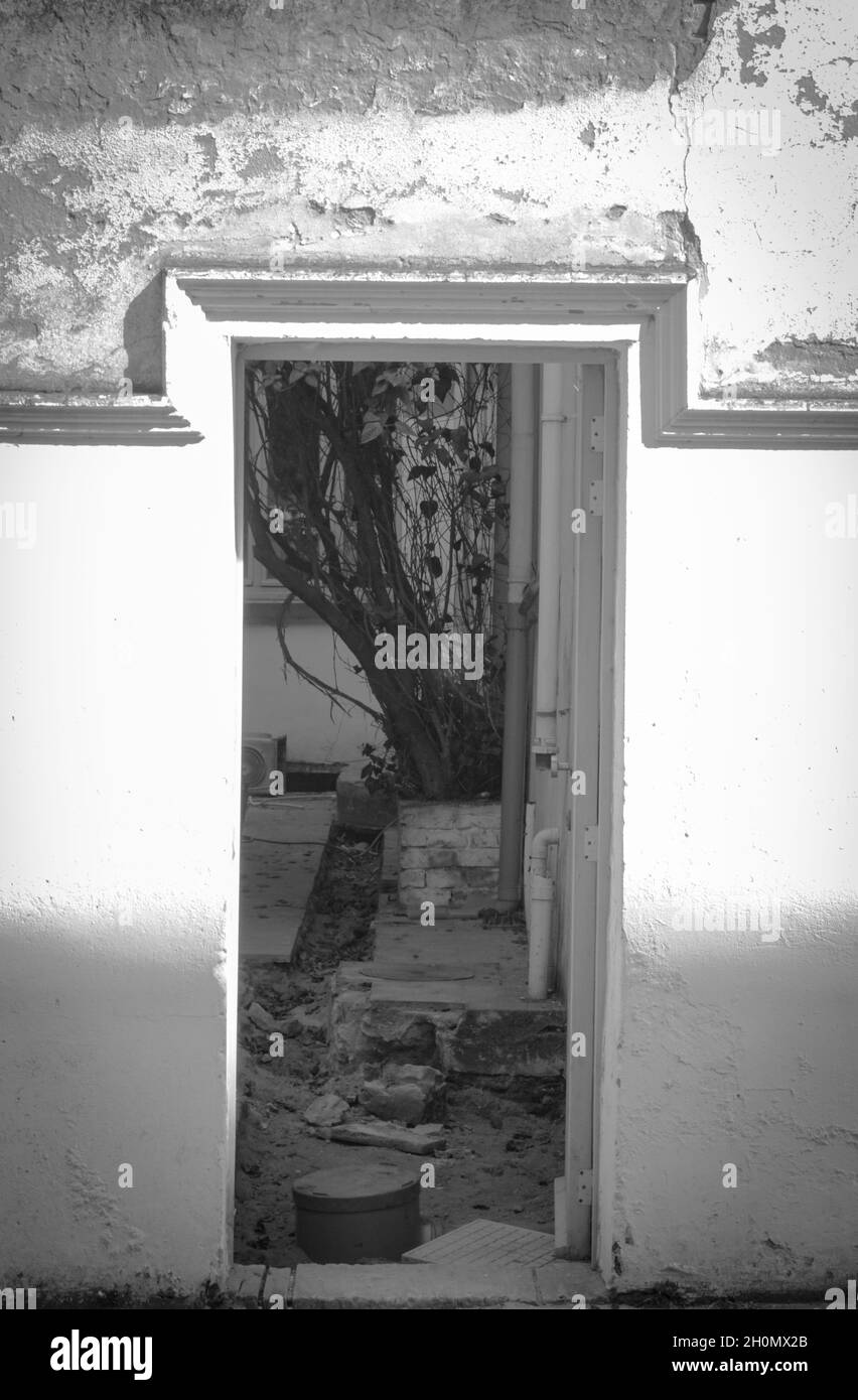 Colpo verticale di una vecchia porta, pavimento rovinato e pareti. Foto Stock